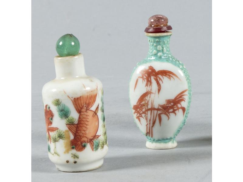 CHINE : Deux tabatières en porcelaine à décor peint de bambous et poissons.  Bouchons en pierre rapportés.  Hauteur : 5.5 cm.  On joint une tabatière en pierre sculptée à décor d'un phoenix.  Hauteur : 7.5 cm.