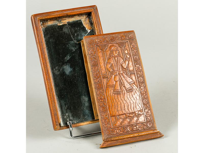 PERSE : Miroir secret en bois précieux à décor d'un personnage sculpté en léger relief dans une frise de fleurs.  XIXe siècle.  Dim.: 21x12 cm. (miroir cassé)