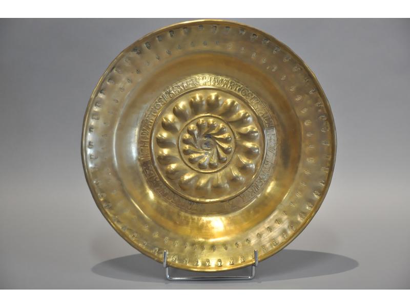 ALLEMAGNE : Plat à offrandes en laiton à décor estampé et repoussé. Epoque XVIIème siècle. Diamètre : 36 cm. (petites restaurations au plomb au centre du bassin)