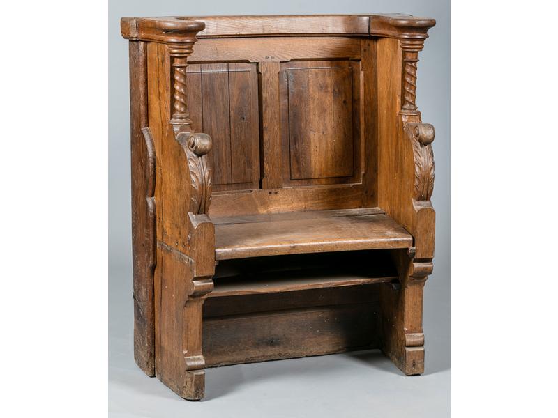 Stale d'église en chêne.  les côtés et les accotoirs sculptés de petites colonnes torsadées et feuillages.  Assise sur charnière.  Epoque XIXe siècle.  Hauteur : 107 cm.  largeur : 93 cm. (piqûres sur les côtés)