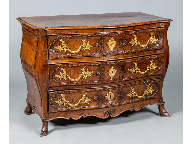 Commode, galbée toutes faces, en noyer ouvrant par trois tiroirs à traverses. Elle repose sur quatre pieds sabots. Elle est décorée de moulures. Epoque XVIIIème siècle. Ornementations en bronze : poignée et entrées de serrure. (Restaurations d'usage et fente au plateau). Dimensions : 87x122x67.5 cm