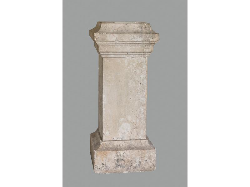 Piédestal en pierre en forme de gaine à chapiteau.  Dim.: 101x41x41 cm.