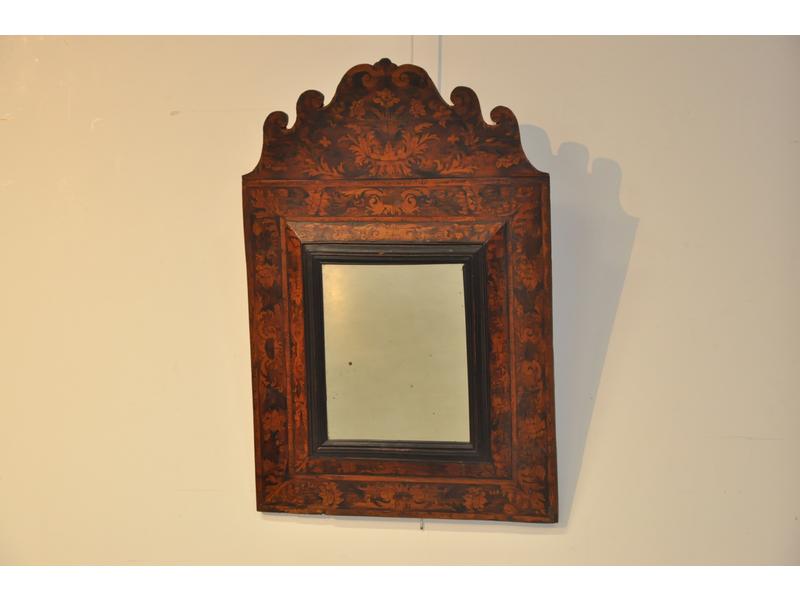 Miroir rectangulaire dans un encadrement en bois indigène marqueté de fleurs et feuillages, surmonté d'un fronton ouvragé et marqueté. Travail du Languedoc.  Epoque fin XVIIe siècle (éclats de marqueterie en partie basse et renforts modernes au dos du miroir. Dim. 86 x 58 cm.