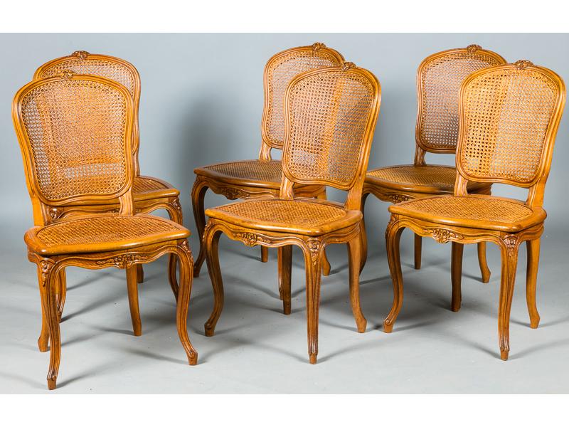 Suite de six chaises cannées de style Louis XV en bois naturel mouluré et sculpté de fleurettes.  Bon état, avec galettes en tissu)