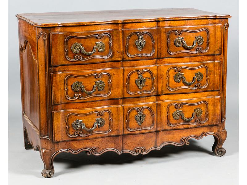 Commode arbalète en noyer naturel mouluré ouvrant par trois tiroirs en façade à décor de contours et agrafes.  Elle repose sur un piètement cambré à enroulements réunis par une traverse mouvementée.  Provence.  XVIIIe siècle.  Dim.: 87x67x125 cm. (restaurations postérieures)
