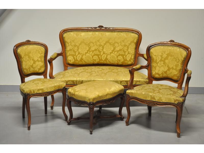 Mobilier de salon de style Louis XV en noyer naturel mouluré et sculpté de fleurettes comprenant deux fauteuils cabriolets, deux chaises, un petit canapé et un petit tabouret.