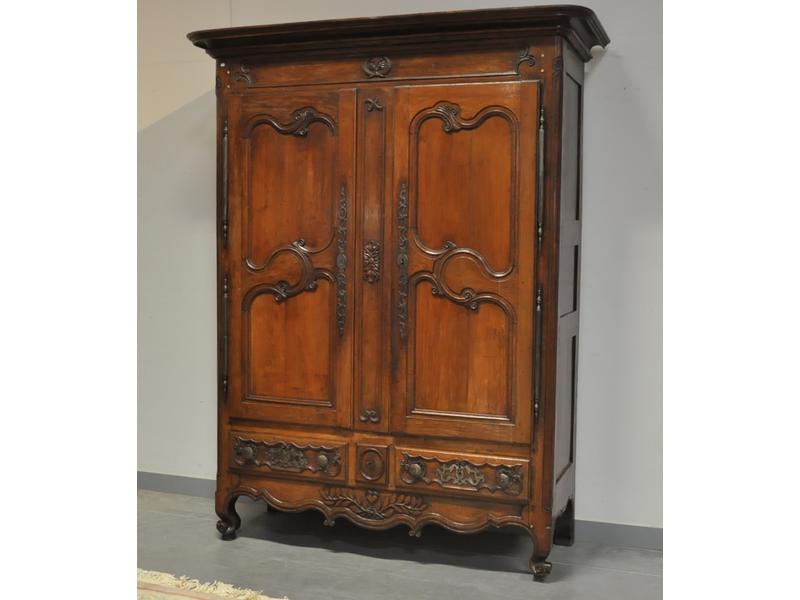 Belle armoire de mariage en chêne mouluré et sculpté.  Corniche droite.  Elle ouvre par deux portes et une série de trois tiroirs en traverse.  Pieds antérieurs à enroulement.  Belle ferronnerie.  Fin XVIIIe siècle.  Dim.: 230x180x63 cm.