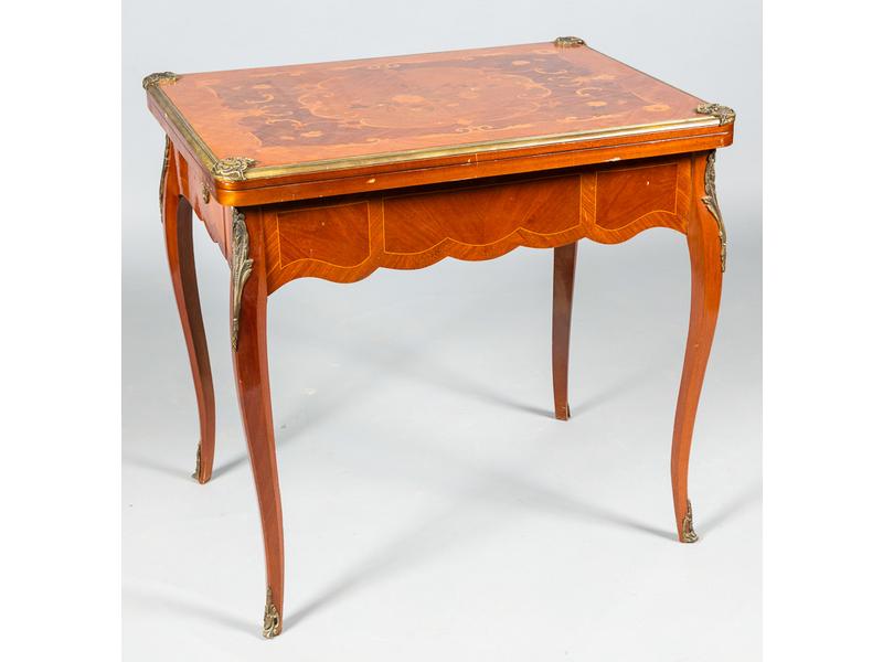 Table à jeu de style Louis XV à décor floral marqueté. Le plateau orné d'une lingotière et écoinçons rocailles ouvrant sur un tapis feutré. Dim. : 76 x 80 x 60 cm.