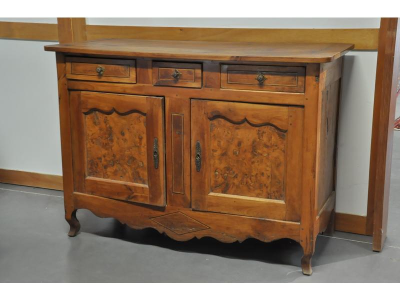 Buffet-bas Bressan en noyer, chêne et loupe d'orme ouvrant par trois tiroirs en ceinture et deux portes. Epoque XIXème siècle. Dimensions : 101x143x59 cm