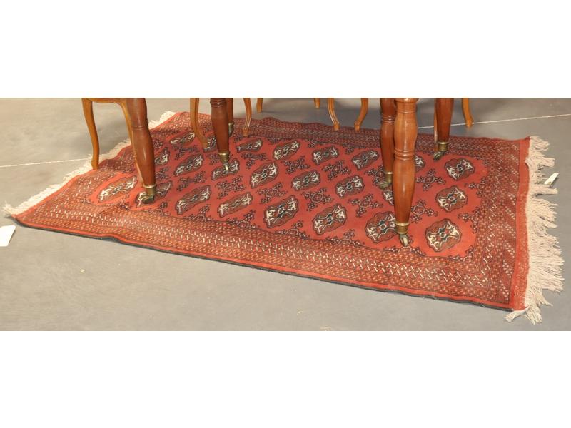 BELOUCH : Tapis en laine à décor de gühls sur fond rouge.  Dim.: 192x127 cm.
