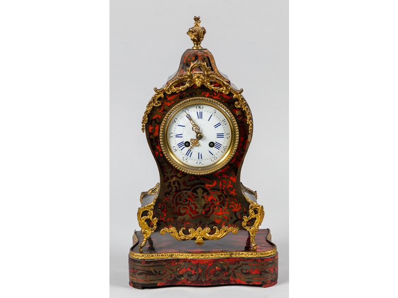 Petit cartel de style Louis XV en bois et placage de bois noirci marqueté de laiton sur fond d'écaille rouge et petite ornementation de bronze.  Cadran émaillé, mouvement signé Japy et Cie.  Epoque fin XIXe siècle.  Hauteur avec socle : 42 cm.