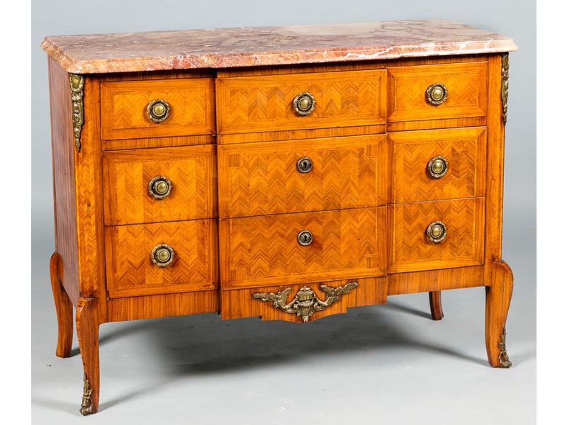 Commode de style transition Louis XV-Louis XVI en bois de placage et à façade à ressaut. Elle ouvre par une série de cinq tiroirs sur toirs rangs et repose sur quatre pieds galbés. Dessus de marbre. Dim: 90x115x48cm
