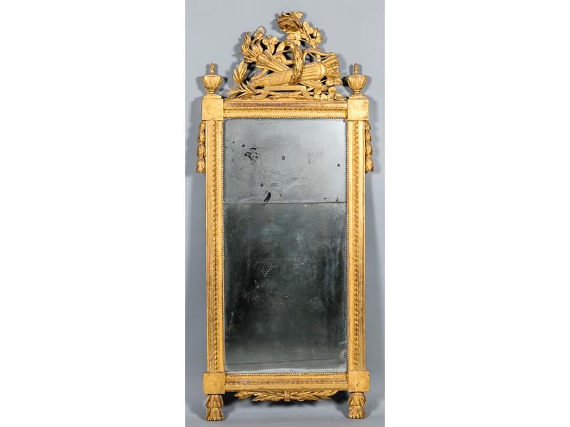 Beau miroir trumeau à fronton en bois sculpté et doré à décor de carquois, couronne de lauriers et urnes cannelées.  Epoque Louis XVI.  Dim.: 174x77 cm. (quelques accidents et manques)