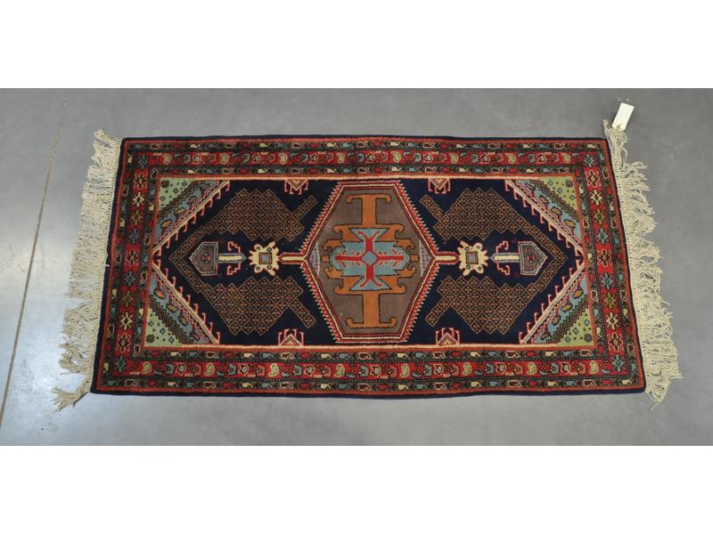 Petit tapis en laine polychrome à décor géométrique.  Dim.: 176x90 cm.