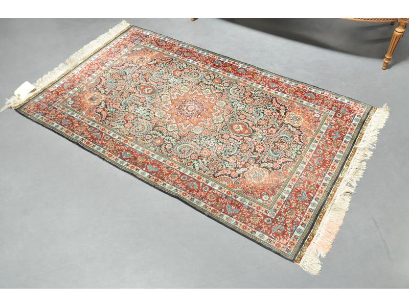 Joli petit tapis en laine et soie à décor polychrome. Dim. : 151 x 90 cm (quelques franges teintées).