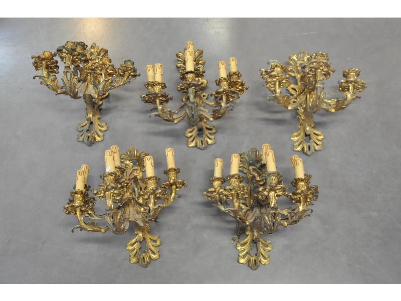 Suite de cinq grandes appliques en bronze doré de style Louis XV éclairant à six bras de lumière et à décor feuillagé. Epoque fin XIXème. H. 42 x P. cm. (manque quelques bobèches).