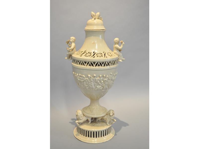 SEPTFONTAINES Luxembourg (probablement) : Pot pourri en terre cuite à émail écru composé d'un pot couvert balustre à décor ajouré orné de deux petits enfants assis (couvercle restauré).  Le socle orné de trois lions.  Epoque début XIXe siècle.  Hauteur totale : 65 cm.