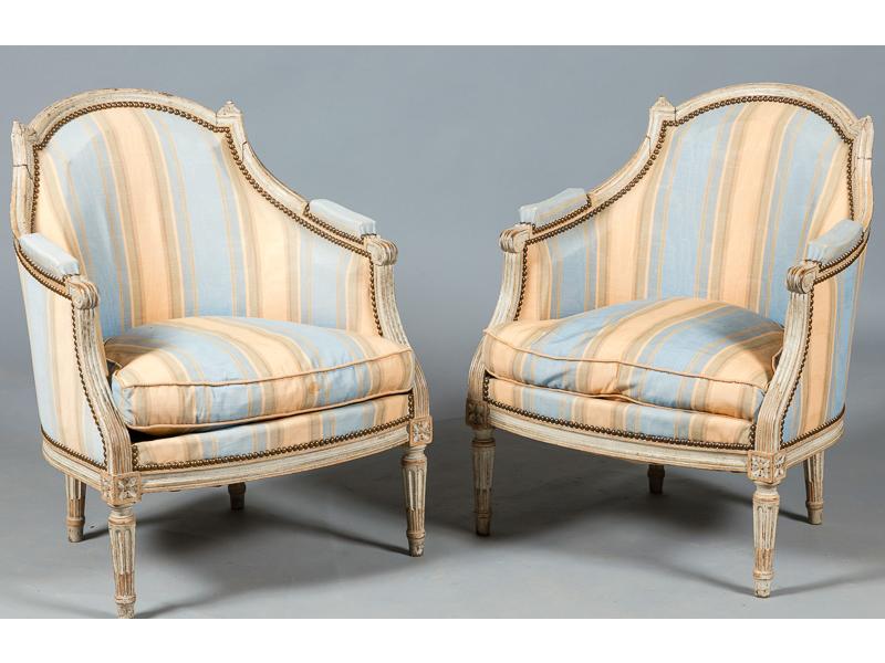 Paire de bergères de style Louis XVI à dossier chapeau de gendarme en bois mouluré et laqué blanc, reposant sur quatre pieds fuselés et cannelés
