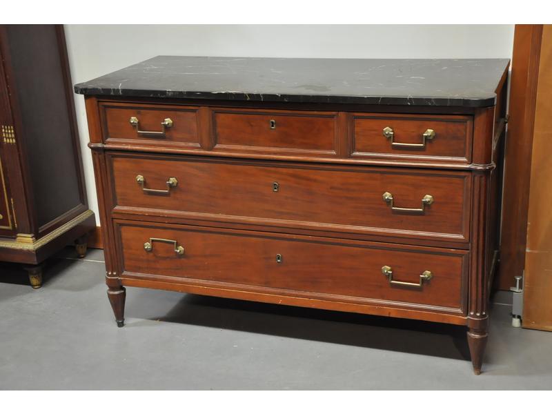 Commode Louis XVI de forme rectangulaire en placage d'acajou ouvrant par trois tiroirs.  Plateau de marbre gris veiné blanc (moderne) reposant sur des montants cannelés et des pieds toupies.  Fin XVIIIe début XIXe siècle.  Dim.: 83x128x60 cm.