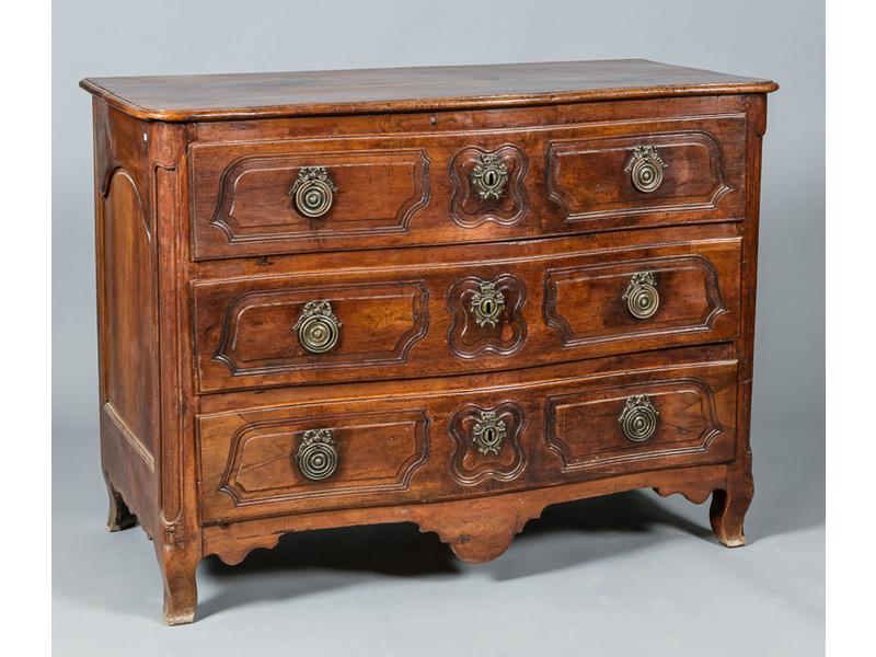 Commode en noyer à façade galbée ouvrant par trois tiroirs, plateau en bois. Décor d'encadrement mouluré. Entrées de serrure et poignées en laiton. Reposant sur quatre pieds cambrés. Travail de la fin du XVIIIe siècle. Dim.: 100x132x70 cm.