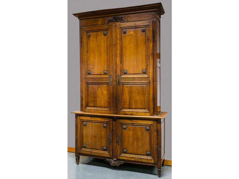 Joli buffet deux-corps en acajou naturel, partie supérieure en léger retrait.  il ouvre par quatre portes en façade moulurées et sculptées de cannaux et rosaces.  Traverse supérieure ornée d'une composition de fleurs de lauriers.  Montants à cannelures reposant sur un petit piètement relié par une t