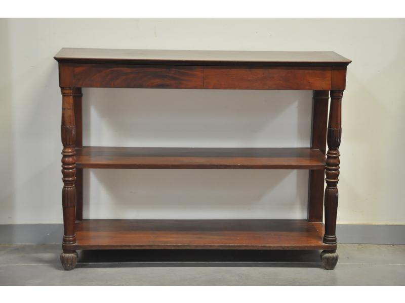 Console d'époque Restauration en acajou et placage d'acajou de forme rectangulaire, ouvrant en ceinture par deux tiroirs et reposant sur deux pieds antérieurs à balustres cannelées et à deux tablettes d'entrejambe. Dim. 97 x 130 x 42 cm.