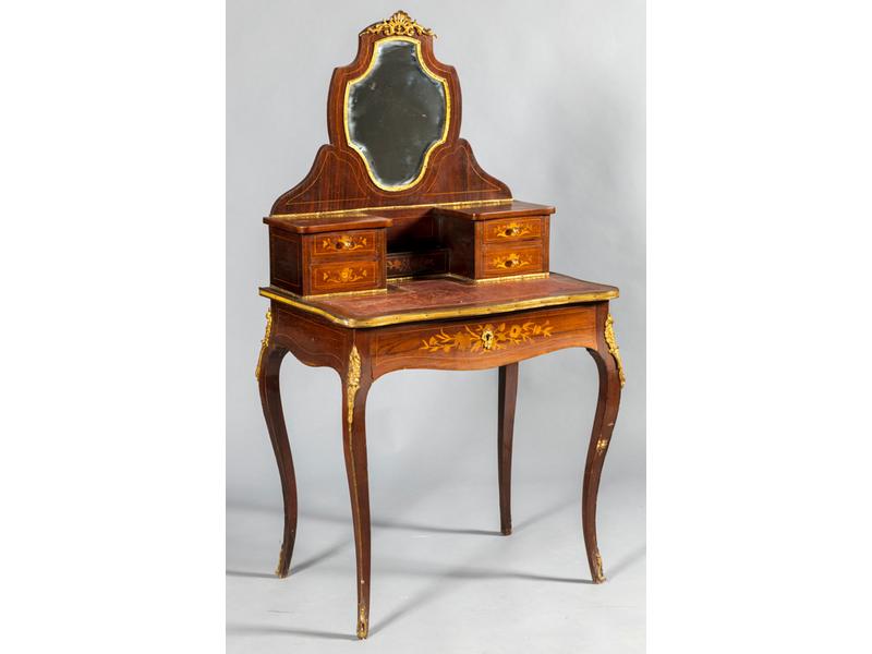 Coiffeuse de style Louis XV en placage de palissandre à décor marqueté de fleurettes.  Plateau gainé de cuir rouge (usures) orné d'un miroir biseauté dans un encadrement en bronze doré ouvrant par quatre petits tiroirs en gradin et un tiroir en ceinture.  Epoque fin XIXe siècle.  Dim.: 144x76x50 cm.