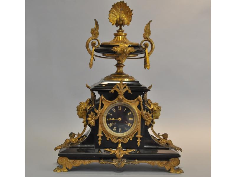 Importante pendule d'époque Napoléon III en marbre noir ornée de riches bronzes dorés à décor de paon, chimères, mascarons de femmes, guirlandes et griffes de lion.  Mouvement signé Boisnard Marseille.  Hauteur : 57 cm. (manque une aiguille)