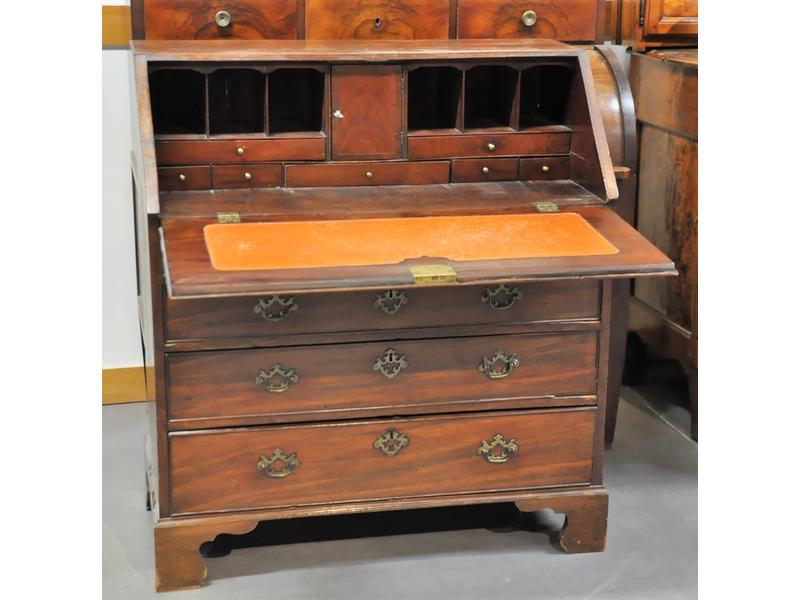 Commode scriban anglaise ouvrant par un abattant formant pupitre gainé de cuir et quatre tiroirs en façade.  Entrées de serrures et poignées en laiton.  Dim.: 105x94x48 cm.