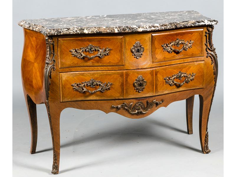 Commode de style Louis XV galbée toutes faces ouvrant par trois tiroirs sur deux rangés en marqueterie de bois de rose. Plateau en marbre gris veiné blanc. Ornementation en bronze. Dim. : 86x120x53 cm.