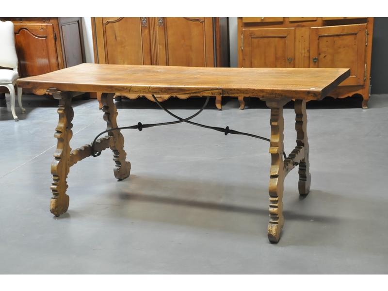 Table espagnole en noyer et bois fruitier.  Plateau rectangulaire (avec enture sur côté) reposant sur un piètement relié par une entretoise en fer.  Dim.: 79.5x179x70 cm.