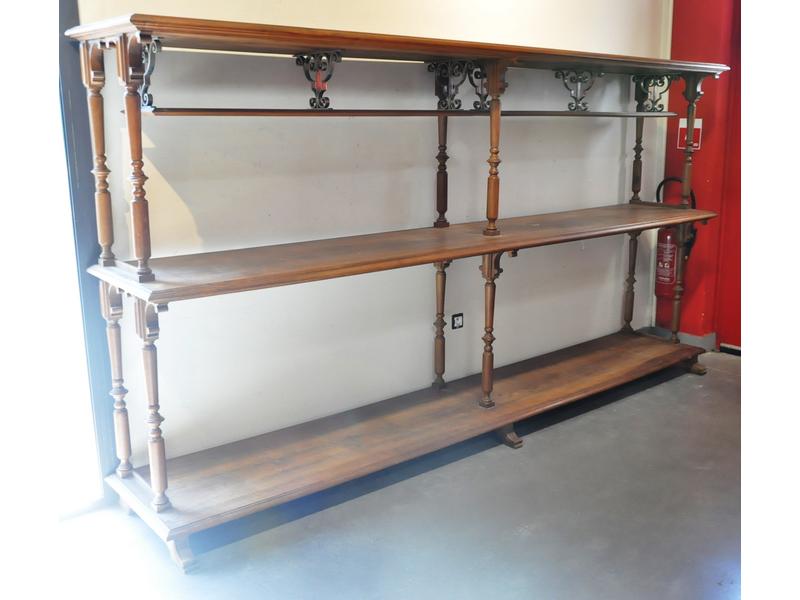 Présentoir en noyer à trois plateaux reposant sur six colonnes tournées.  Fin XIXe siècle.  Dim.: 164x305x55 cm.