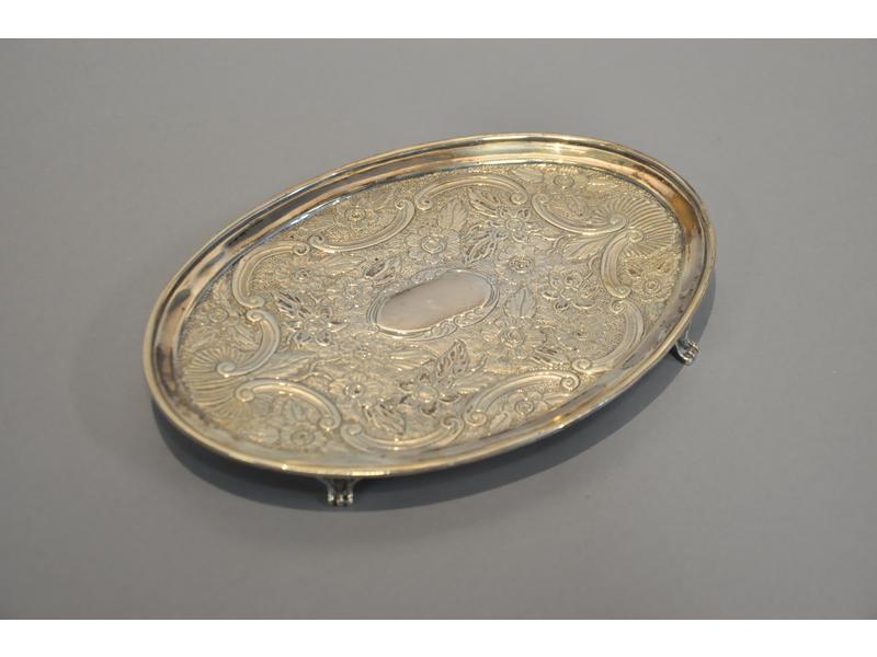 Vide-poche en argent de forme ovale à décor estampé d'un cartouche, fleurs et rinceaux.  Il repose sur quatre petits pieds cambrés.  Travail étranger XIXe siècle.  Poids : 137g.