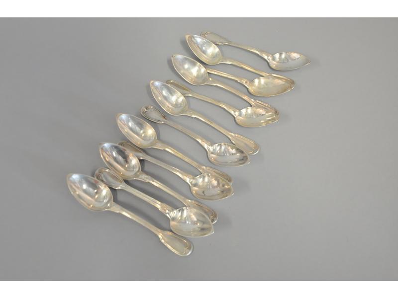 Série de douze cuillères à thé en argent modèle à filets, spatule à décor d'un écusson chiffré (poinçon Minerve, 325g), et six cuillères à oeuf en argent (145g).  Poids total : 470g.