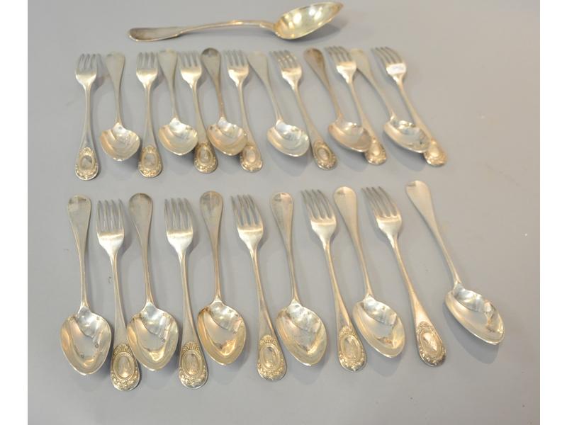Douze grands couverts en argent (poinçon Minerve) de style Louis XVI spatule à décor d'un médaillon chiffré dans un entourage de rangs de perles surmontés d'une coquille.  On joint une cuillère à ragoût, modèle à filets.  Poinçon Michel Ange (Paris 1819-1838).  Poids total : 1872g.