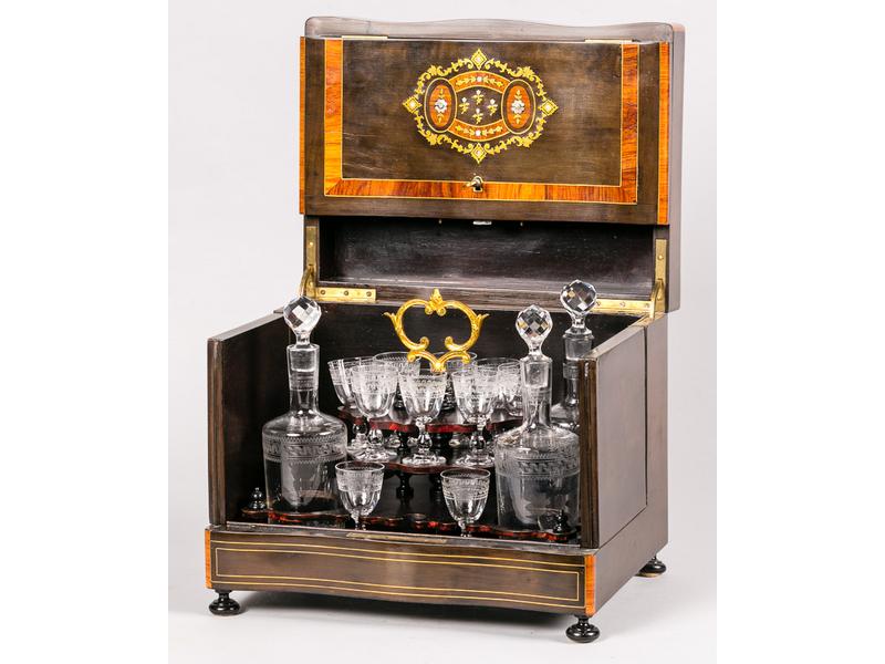 Cave à liqueur en placage de bois teinté, bois de rose marqueté de nacre et laiton. Intérieur comprenant trois flacons (un manquant) et dix verres (six manquant). Epoque Napoléon III.