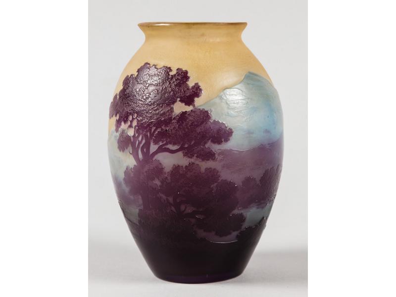 Etablissements GALLE (1904-1936) : Petit vase piriforme en verre multicouches blanc, bleu et violet à décor gravé à l'acide d'un paysage vosgien.  Signé.  Hauteur : 11.5 cm.  Bon état.