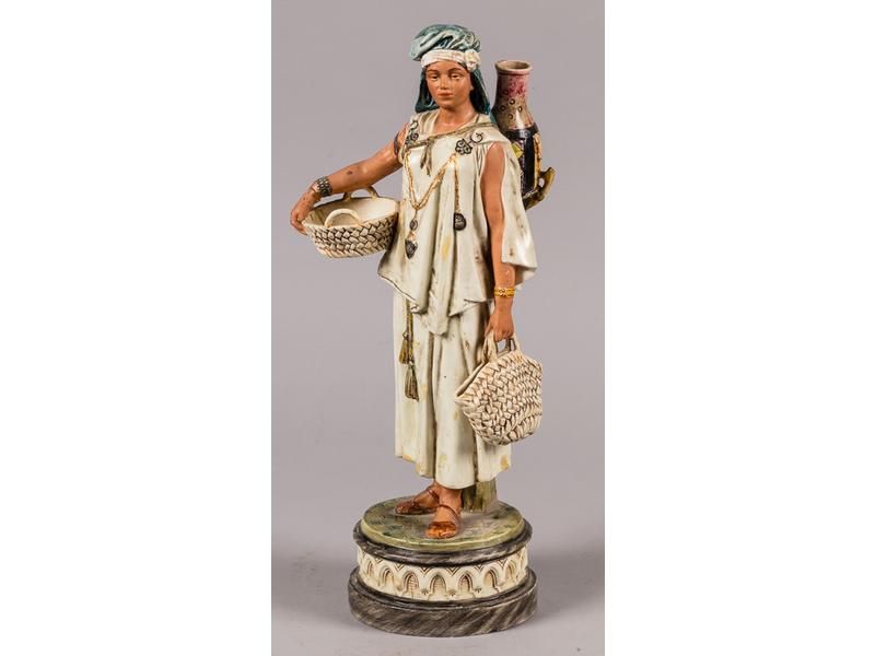 Sujet en faïence fine polychrome représentant une porteuse d'eau orientale.  Epoque fin XIXe siècle.  Hauteur : 43 cm. (nombreux accidents et petites restaurations, en l'état)