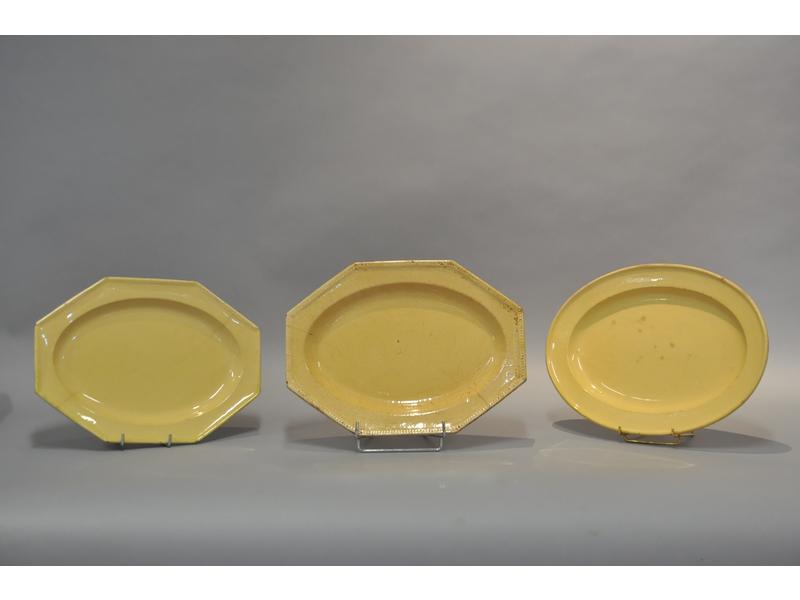 APT : Lot de trois plats : deux plats en faïence jaune de forme octogonale dont un surligné d'une frise de perles, signés BERARD et un plat de forme ovale signé BONNET. Epoque XIX° siècle. (Usures et fêles)