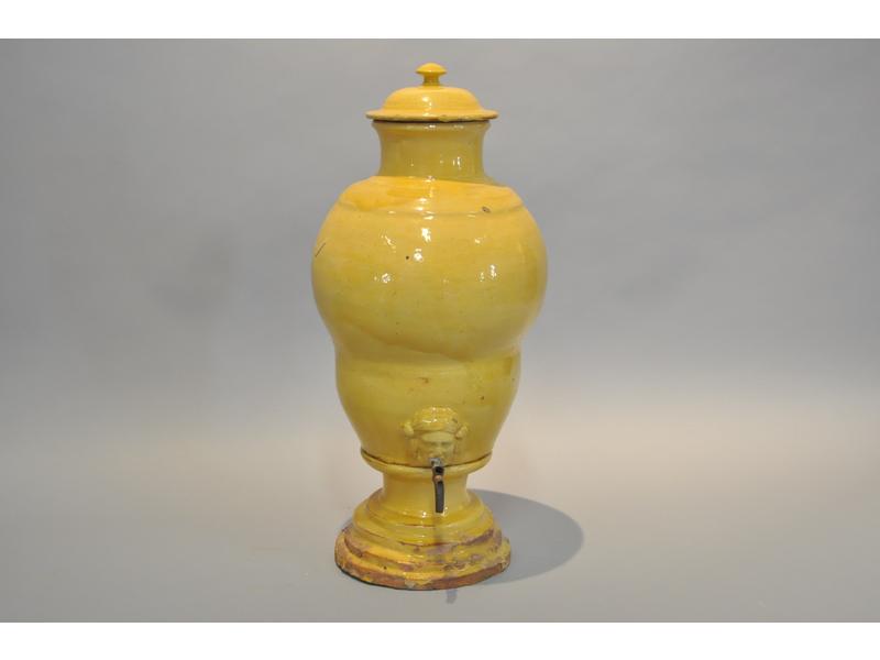 SUD EST : Fontaine en terre cuite vernissée jaune. Bec verseur à décor d'un mascaron. Epoque fin XIXe siècle.  H.: 55cm