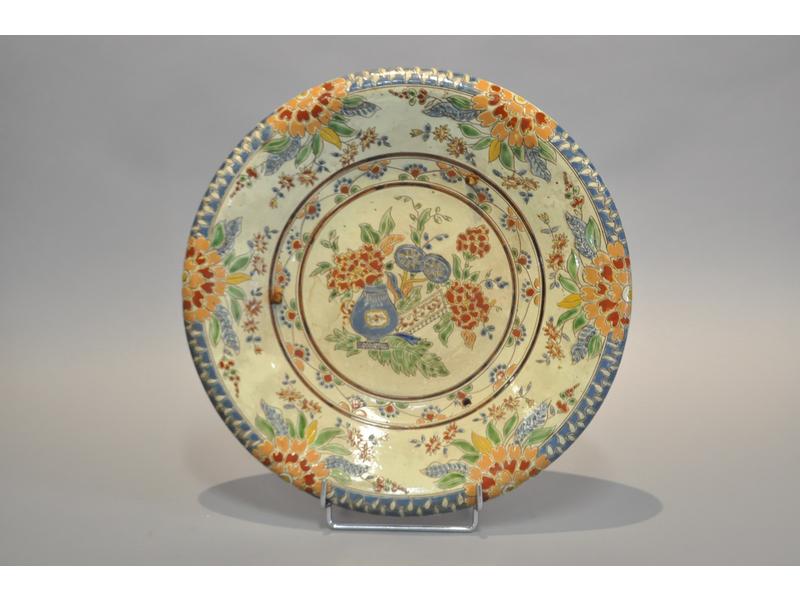 THOUNE : Plat circulaire en faïence à décor émaillé dans le goût chinois.  Diamètre : 37 cm. (deux trous percés pour fixation)