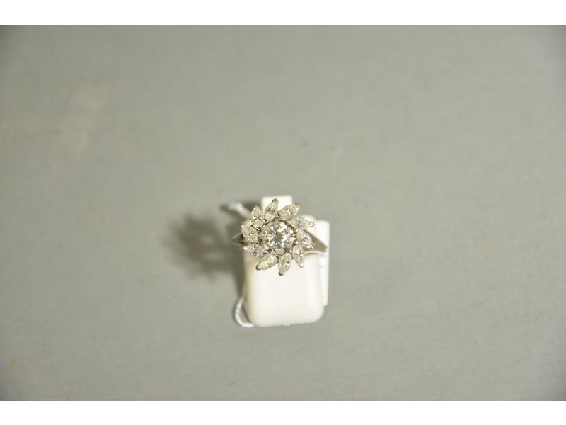 Bague fleur en platine et or gris ornée en serti-griffes d'un diamant central de taille brillant de 0.60 carat environ (5.5x3.5 mm) dans un entourage de dix diamants navettes totalisant 1 carat environ.  Tour de doigt : 51.  Poids brut : 4g90.