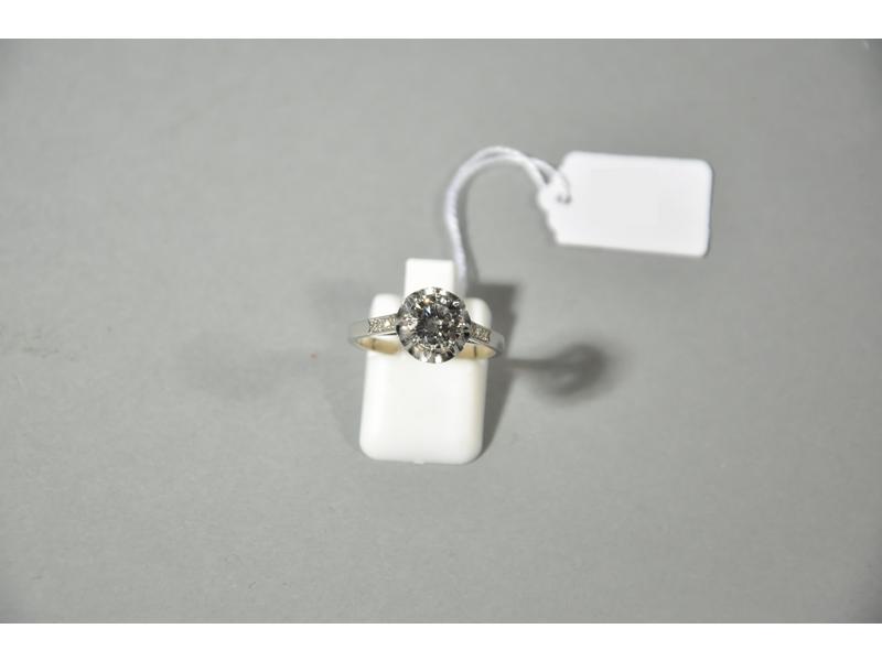 Bague solitaire en or gris ornée en serti-griffes d'un diamant de taille brillant de 1.15 carat env. (6.8x4 mm) de couleur présumée G, de pureté présumée VS2/Si1.  La monture réhaussée de petits diamants à l'épaulement.  Tour de doigt : 55.  Poids brut : 3g80.