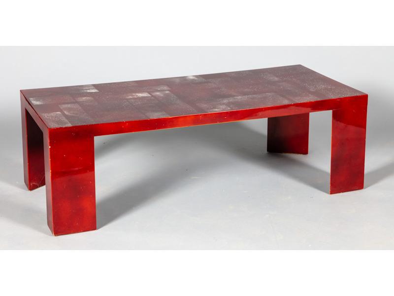 Table basse de forme rectangulaire en bois laqué rouge à décor poudré blanc.  Elle repose sur quatre pieds à section triangulaire.  Dim.: 41x130x58 cm. (petits soulèvement de laque au dessus d'un pied)