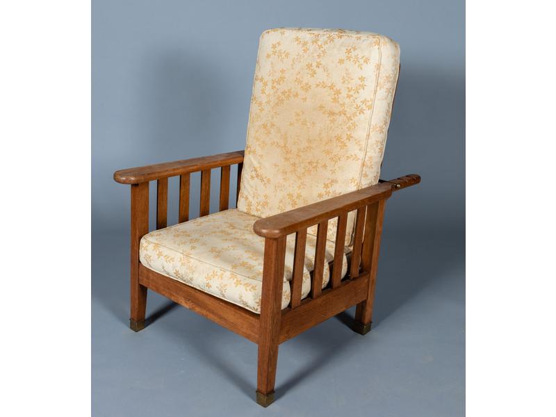Dans l'esprit de Francis JOURDAIN : Fauteuil de repos en chêne à dossier inclinable et réglable et reposant sur des pieds à sabots de laiton.  Vers 1930.  Hauteur dossier : 95 cm.