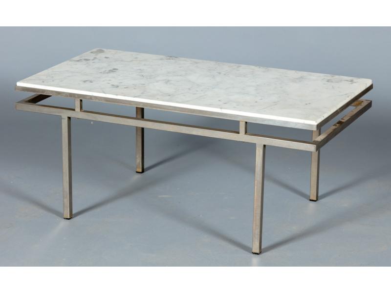 Table basse de forme rectangulaire, plateau de marbre blanc reposant sur un piètement chromé.  Dim.: 39x90x45 cm.