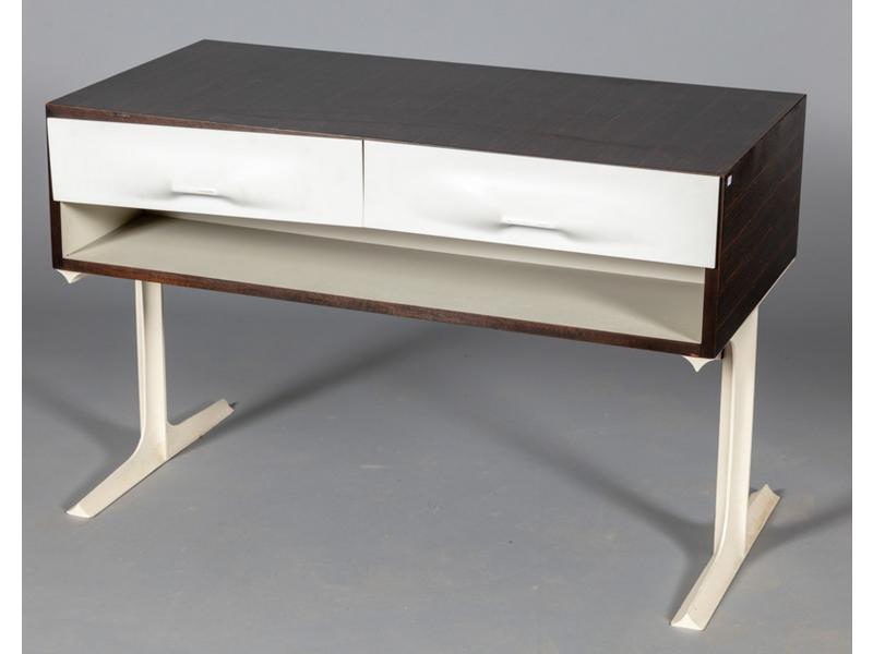 Raymond LOEWY  : Commode double face en bois stratifié reposant sur un piètement métallique en T.  Elle ouvre par quatre tiroirs de part et d'autre, façade en plastique thermoformé.  Dim.: 65x100x50 cm. (tiroir à recoller)