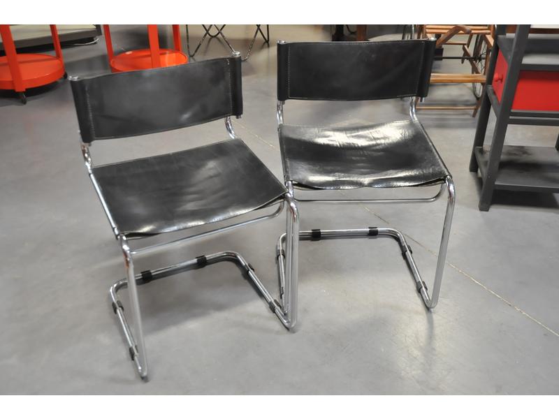 Suite de quatre chaises modernes en cuir noir et piètement en acier tubulaire chromé.