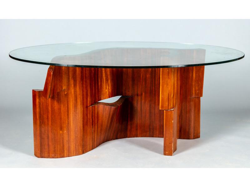 Table de milieu de forme ovale, plateau de verre reposant sur un original piètement de forme mouvementée à lamelles de bois.  Hauteur : 74 cm.  Long.: 172 cm.
