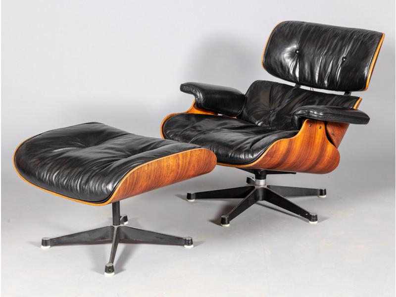 Charles et Ray EAMES : Fauteuil lounge et ottoman en cuir noir et palissandre.  Editeur : Mobilier International. (deux boutons de capitonnage sur l'assise à refixer)